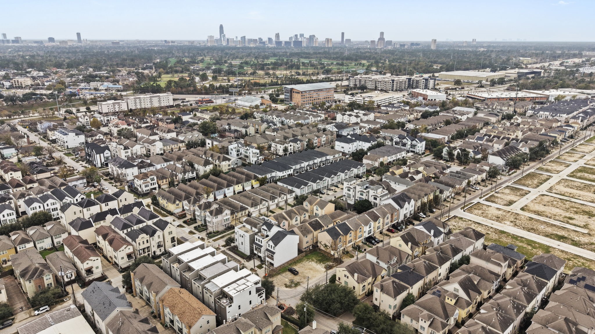 5807 Katy Street Houston, TX 77007 - Photo 19 of 37 A high-altitude aerial perspective showcasing the lot within the context of the surrounding blocks, showing the mix of traditional and modern multi-story town homes and nearby undeveloped land.