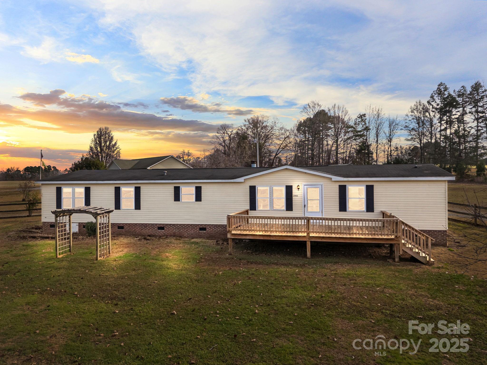 21465 Old Beatty Ford Road Richfield, NC 28137 - Photo 40 of 41 a white house that has a small yard next to a large building