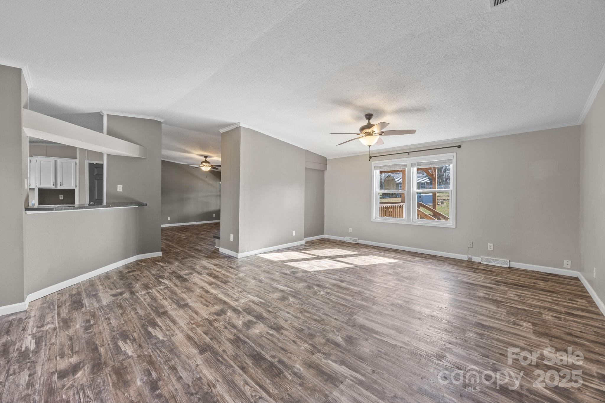 21465 Old Beatty Ford Road Richfield, NC 28137 - Photo 8 of 41 a view of a livingroom with wooden floor and a ceiling fan