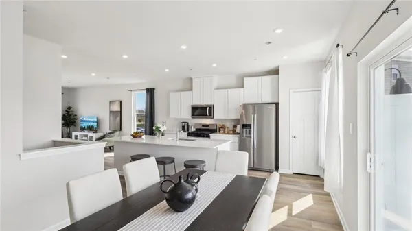 a view of a dining area with furniture and a refrigerator