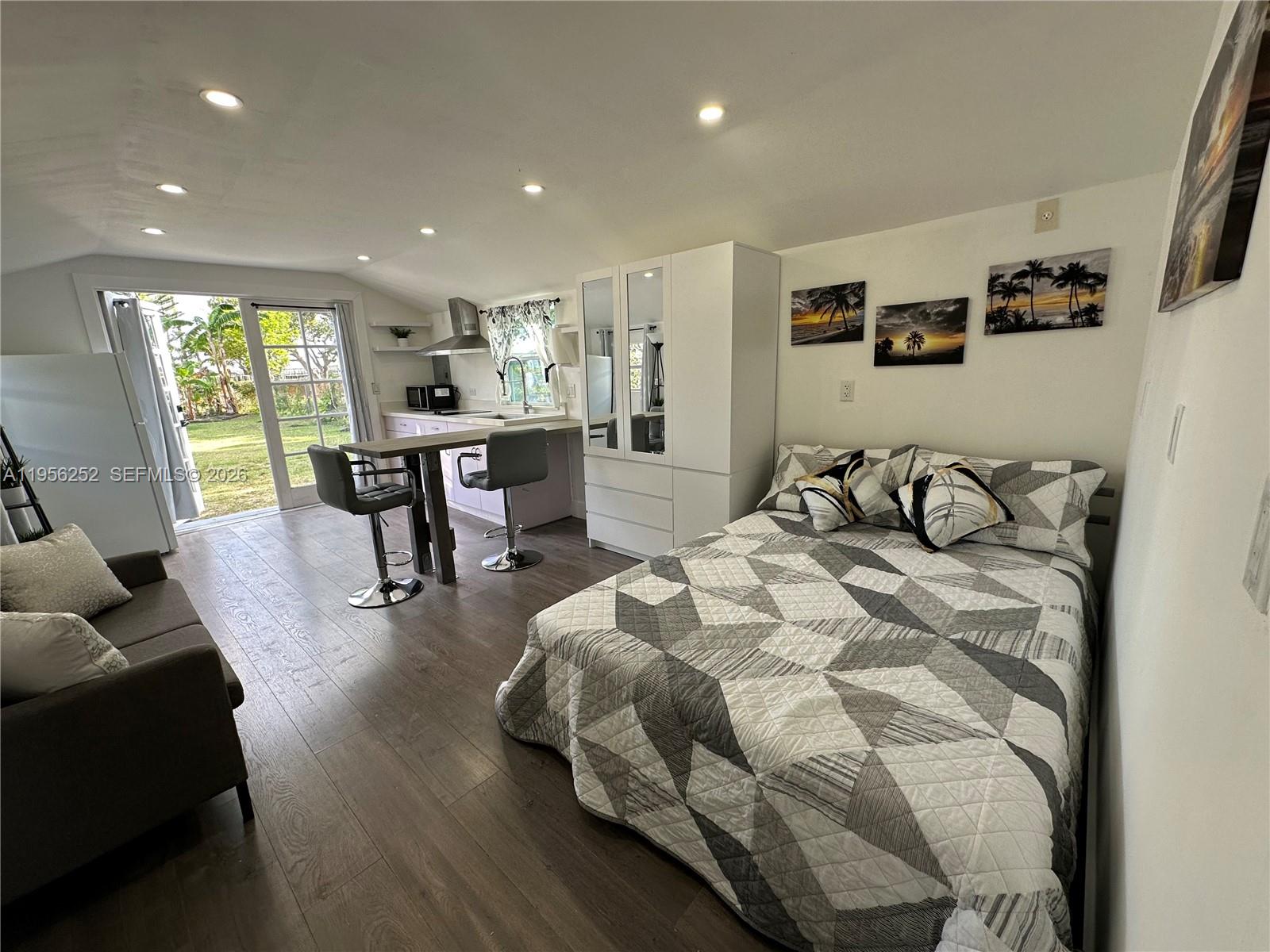 18481 Southwest 208th Street Miami, FL 33187 - Photo 3 of 17 a spacious bedroom with a bed and a table in it