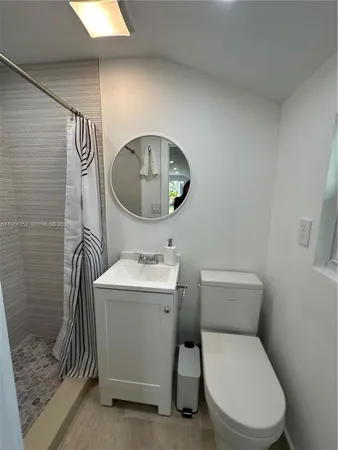 a bathroom with a toilet a sink and mirror