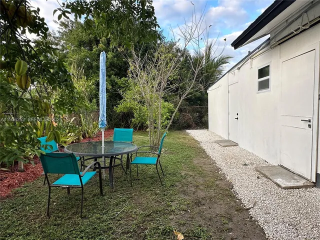 a backyard of a house with table and chairs