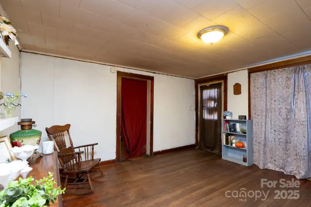 a view of an empty room with furniture and wooden floor