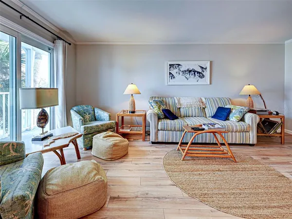 a living room with furniture and a lamp on table with wooden floor