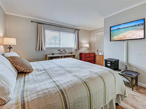 a bedroom with a bed and a lamp on dresser