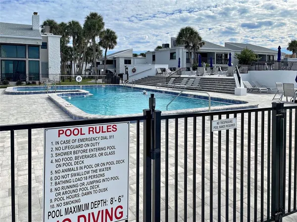 a view of a house with pool and chairs