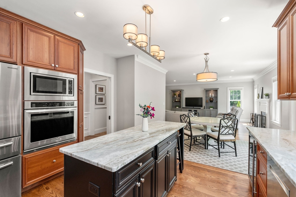 16 Winfield Street Needham, MA 02492 - Photo 10 of 42 a kitchen with a stove a kitchen island with chairs and wooden floor