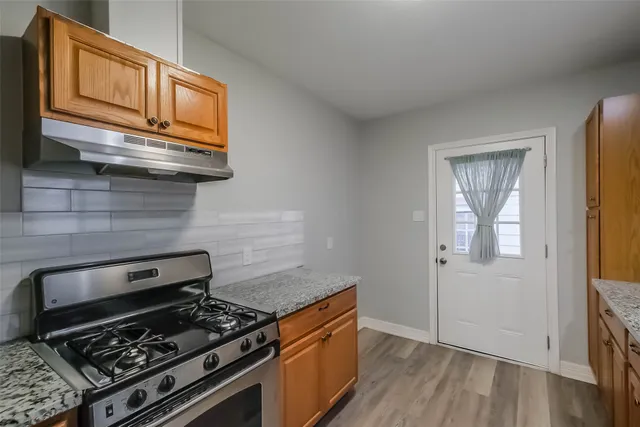 a kitchen with wooden floor and a stove top oven