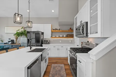 a kitchen with a sink a counter top space stainless steel appliances and cabinets