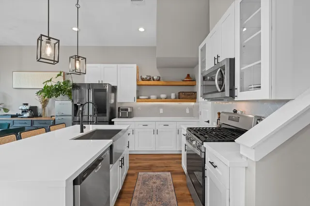 a kitchen with a sink a counter top space stainless steel appliances and cabinets