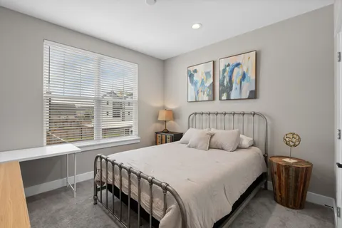 a bedroom with a bed and a flat tv screen on dresser