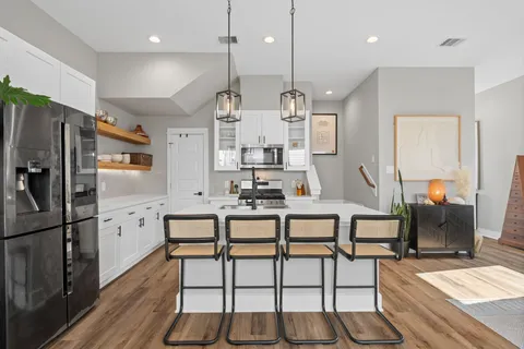 a kitchen that has a sink a stove and a table with chairs