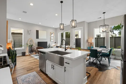 a kitchen with stainless steel appliances kitchen island granite countertop a table chairs and a refrigerator
