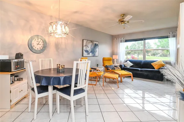 a living room with furniture a flat screen tv and kitchen view