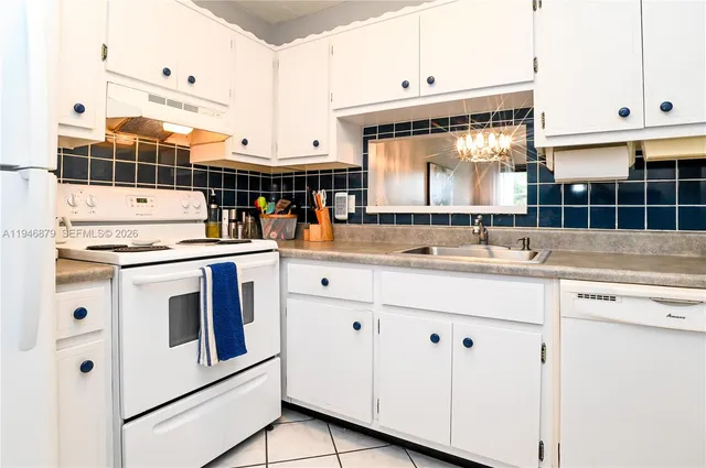 a white refrigerator freezer a stove top oven sitting inside of a kitchen