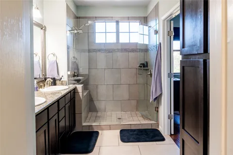 a bathroom with a sink a toilet a window and shower