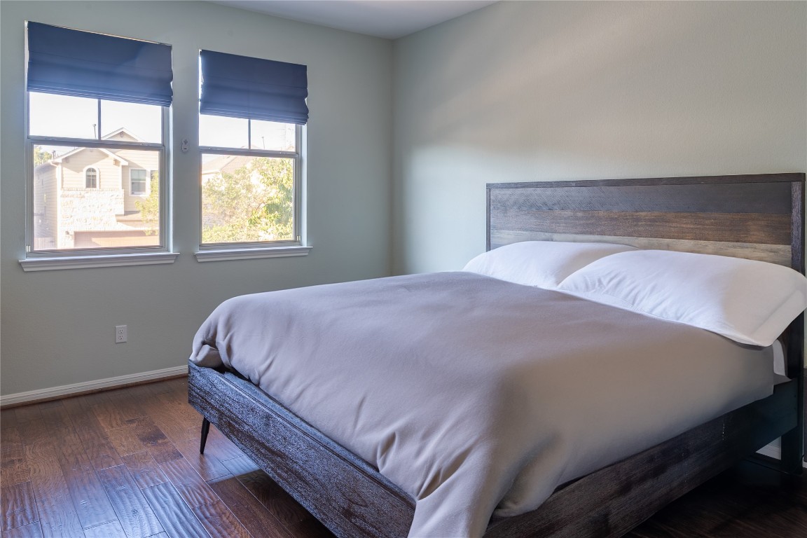 3006 Sea Jay Drive Austin, TX 78745 - Photo 12 of 22 Bedroom featuring dark wood-style flooring and baseboards