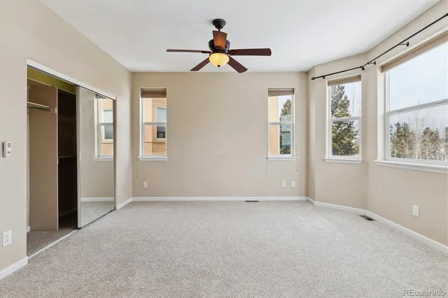 an empty room with windows and closet