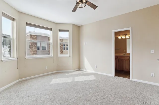 an empty room with closet and windows