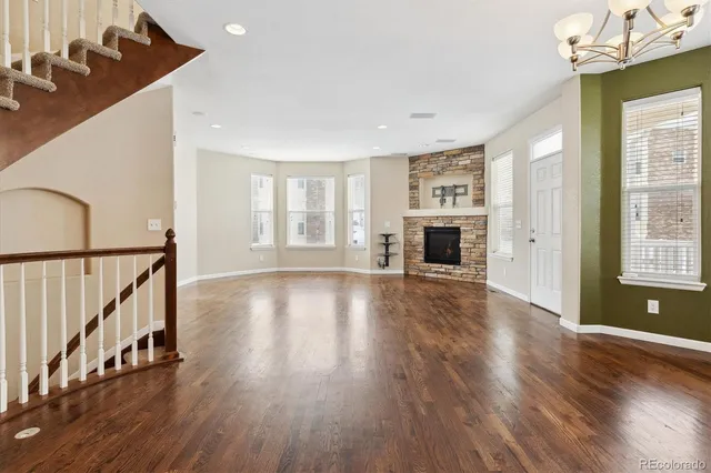 a living room with furniture a fireplace a flat screen tv and a large window
