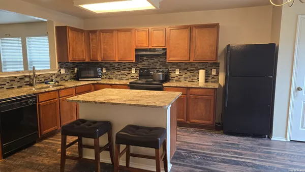 a kitchen with a refrigerator and a stove top oven