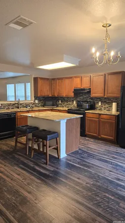 a kitchen with stainless steel appliances granite countertop a stove and a wooden floors