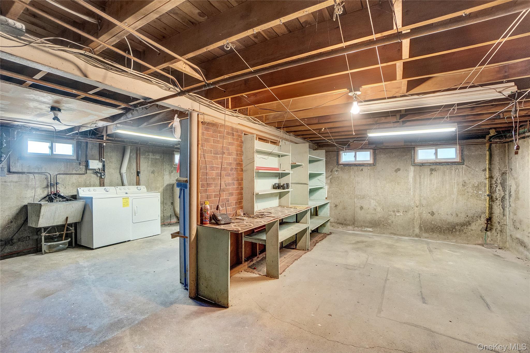 212 Newbridge Road Hicksville, NY 11801 - Photo 13 of 18 Below grade area with separate washer and dryer and a sink