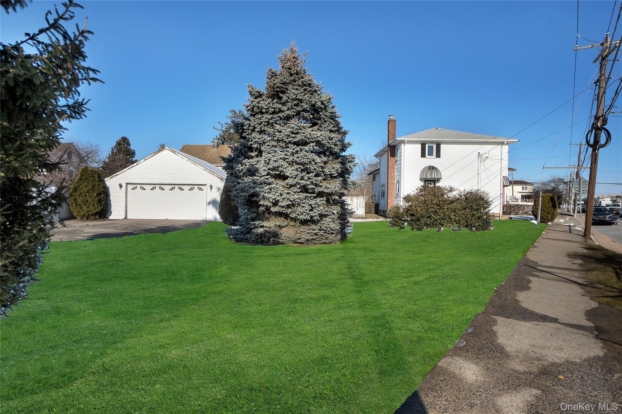 212 Newbridge Road Hicksville, NY 11801 - Photo 16 of 18 View of green lawn with a garage