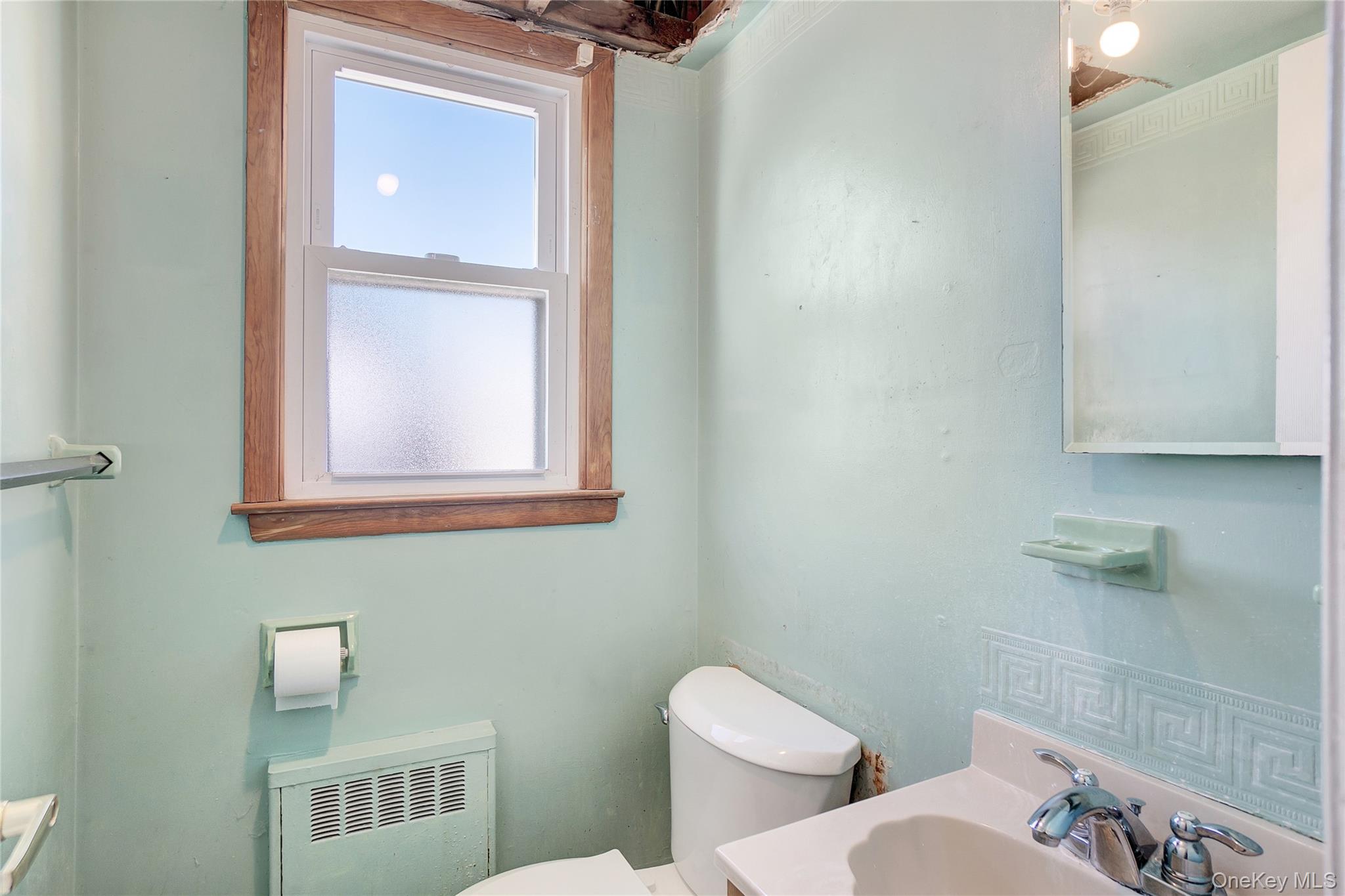 212 Newbridge Road Hicksville, NY 11801 - Photo 6 of 18 Bathroom featuring radiator heating unit and vanity