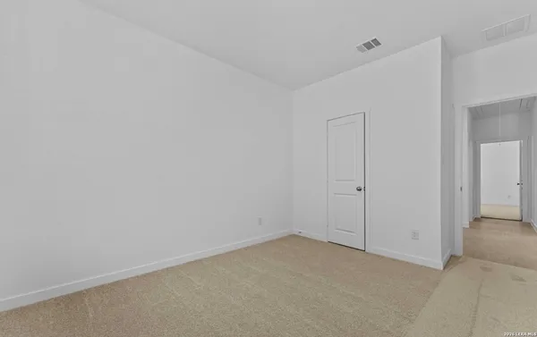 an empty room with a window and a kitchen