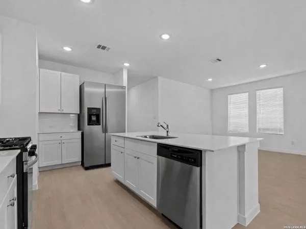 a kitchen with stainless steel appliances granite countertop a sink a stove a refrigerator and a refrigerator