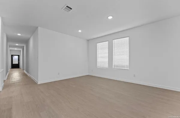 an empty room with windows and entrance to other room