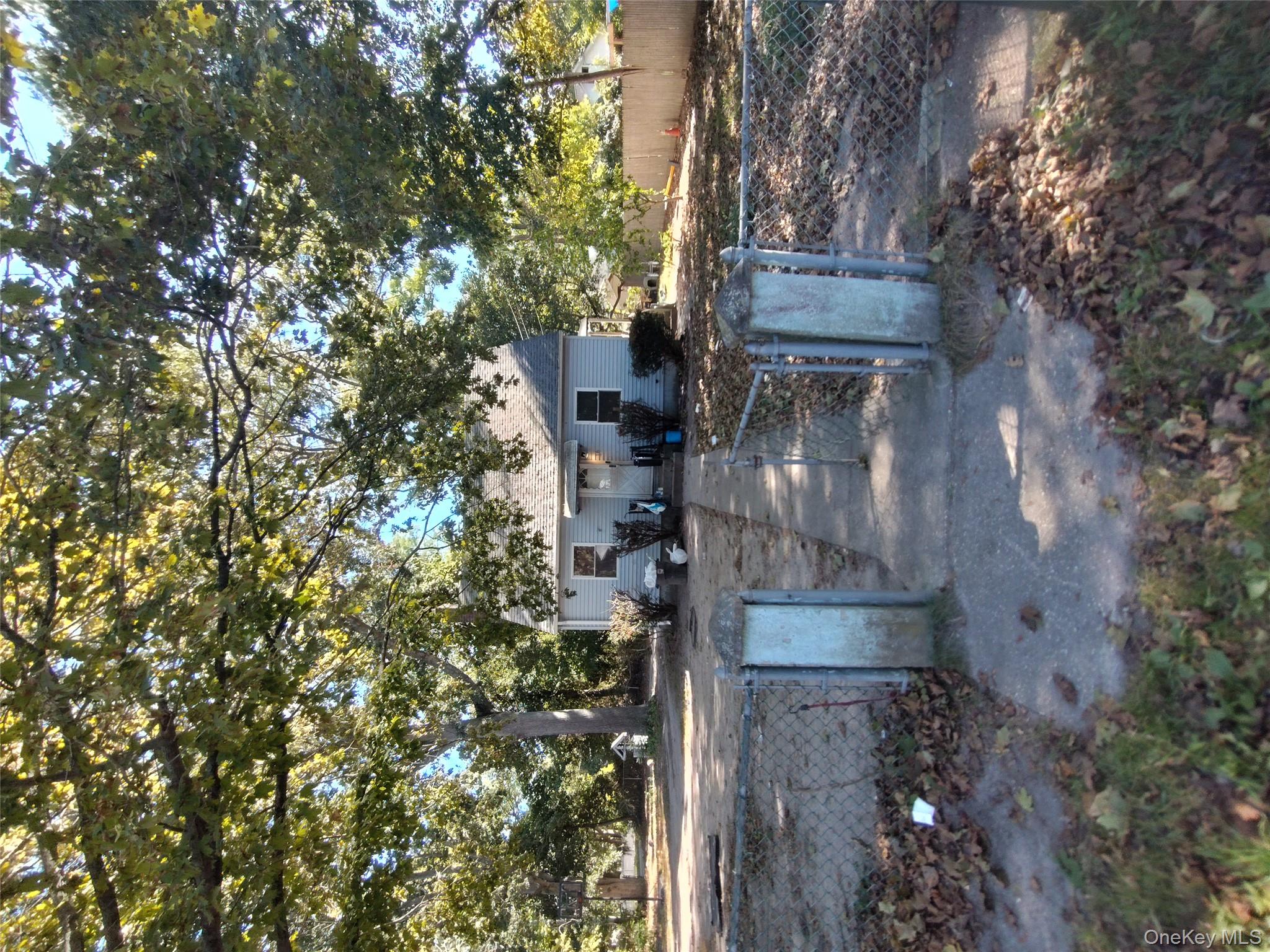 16 Neighborhood Road Mastic Beach, NY 11951 - Photo 1 of 4 a view of a yard with plants and trees