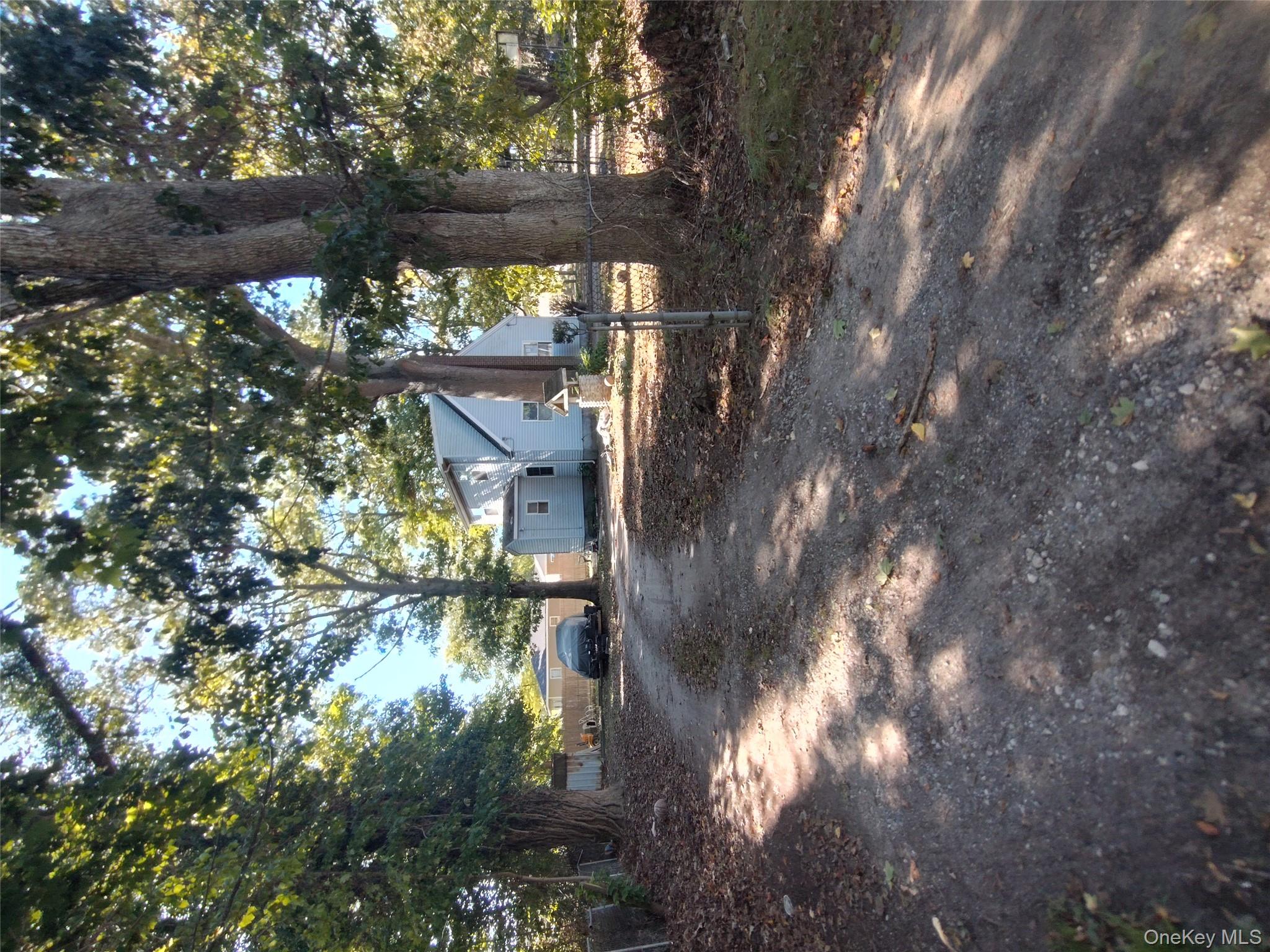 16 Neighborhood Road Mastic Beach, NY 11951 - Photo 2 of 4 a view of a tree in the middle of a yard