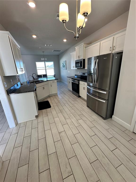 36097 Welsh Glade Road Dade City, FL 33525 - Photo 5 of 35 a kitchen with stainless steel appliances a refrigerator sink and microwave
