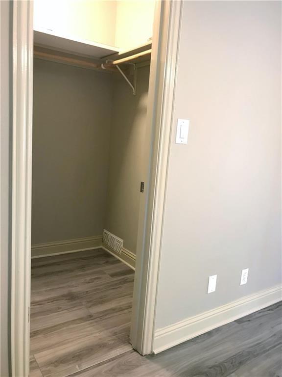 500 East Riverside Drive, Unit 154 Austin, TX 78704 - Photo 10 of 14 Walk-in closet with wood-finish flooring, built-in shelving, and a hanging rod