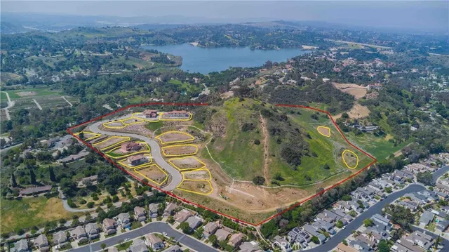 an aerial view of a house with a yard and lake view