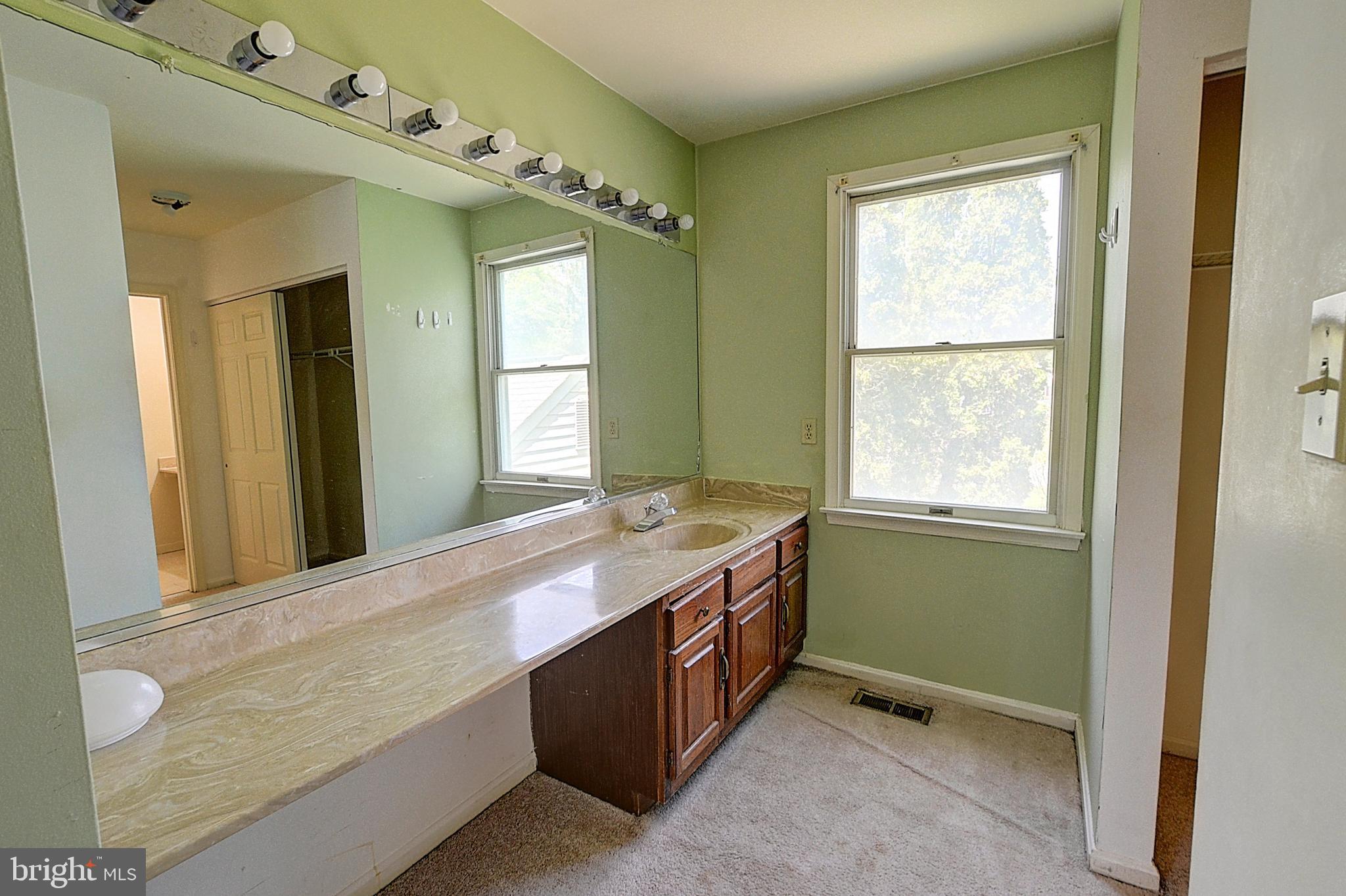 14417 Jaystone Drive Silver Spring, MD 20905 - Photo 21 of 30 a spacious bathroom with a granite countertop sink a mirror and a bathtub next to a window