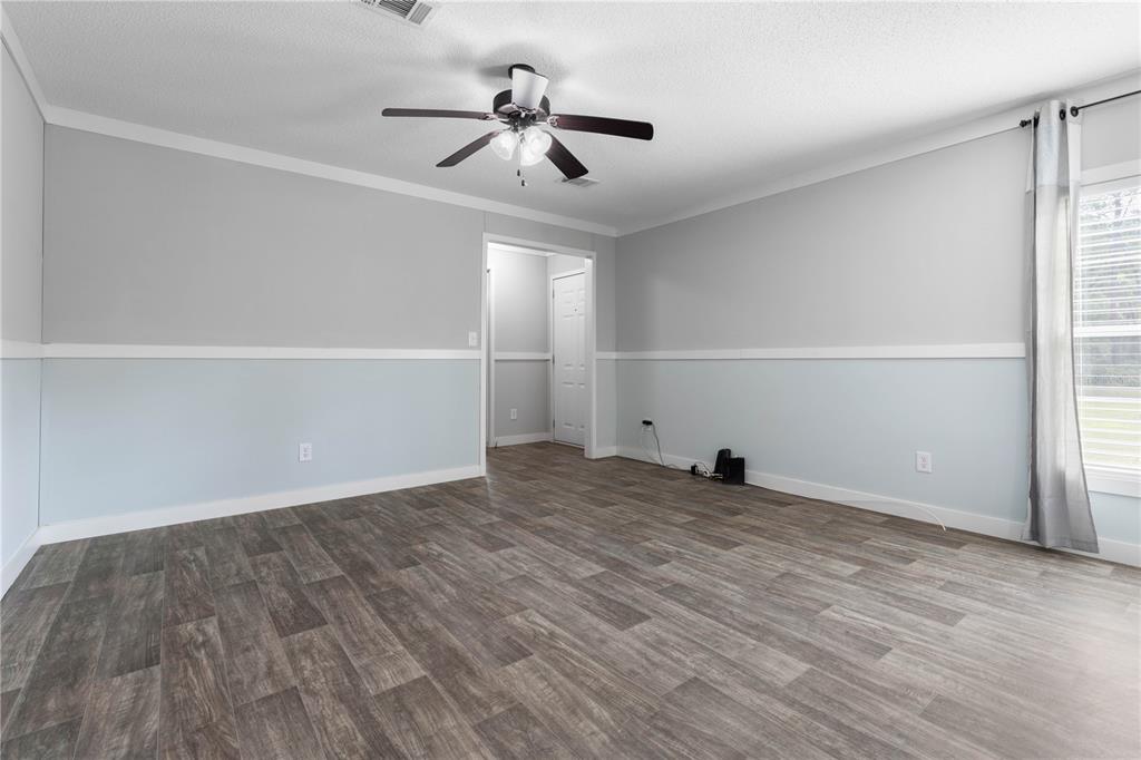 1688 Papaya Street Bunnell, FL 32110 - Photo 11 of 63 a view of empty room with wooden floor and fan