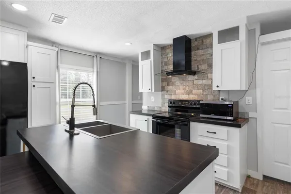 a kitchen with stainless steel appliances granite countertop a stove a refrigerator and a cabinets