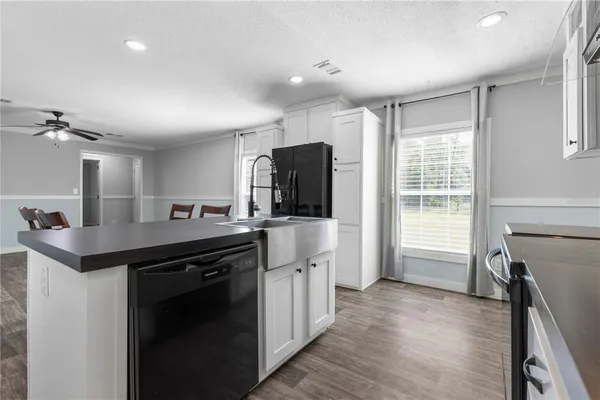 a kitchen with kitchen island a sink appliances and cabinets