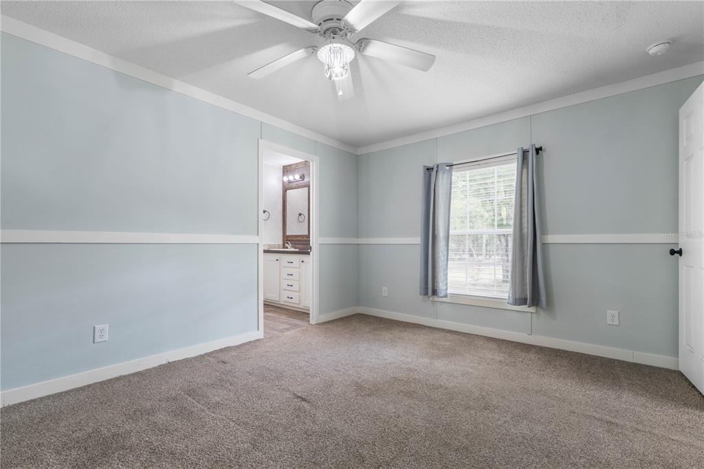 1688 Papaya Street Bunnell, FL 32110 - Photo 19 of 63 an empty room with chandelier fan and windows