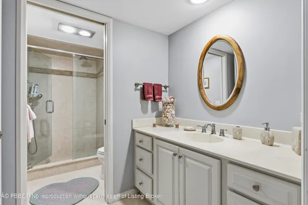 a bathroom with a granite countertop sink a mirror and a shower