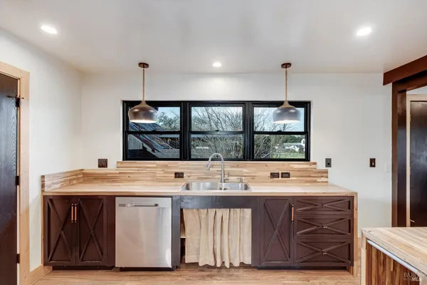 a view of kitchen with stainless steel appliances granite countertop a stove and a sink