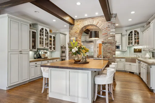 a kitchen with kitchen island granite countertop a white cabinets and chairs
