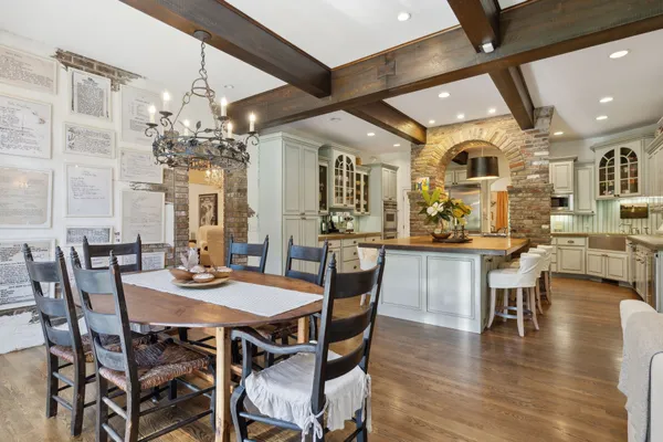 a dining hall with stainless steel appliances a dining table and chairs with wooden floor