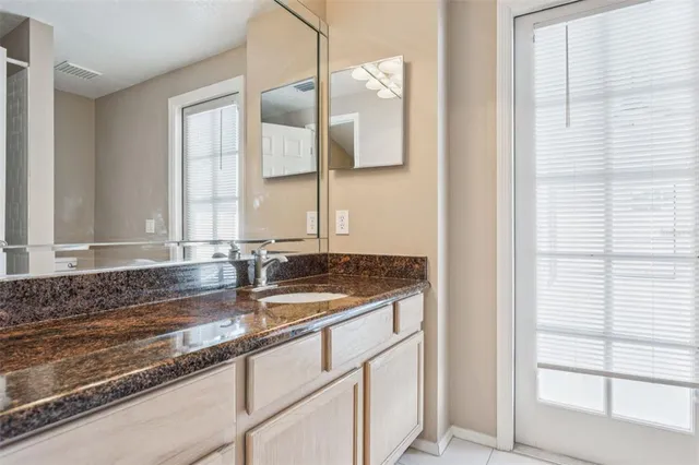 a bed sitting in a spacious bedroom next to a window