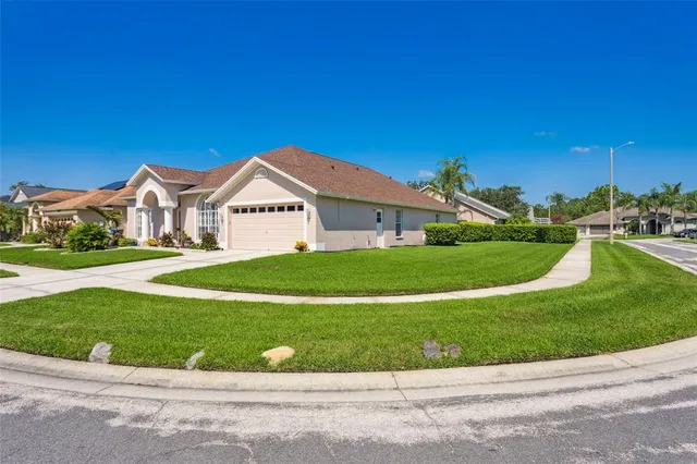 a view of a white house with a big yard and potted plants
