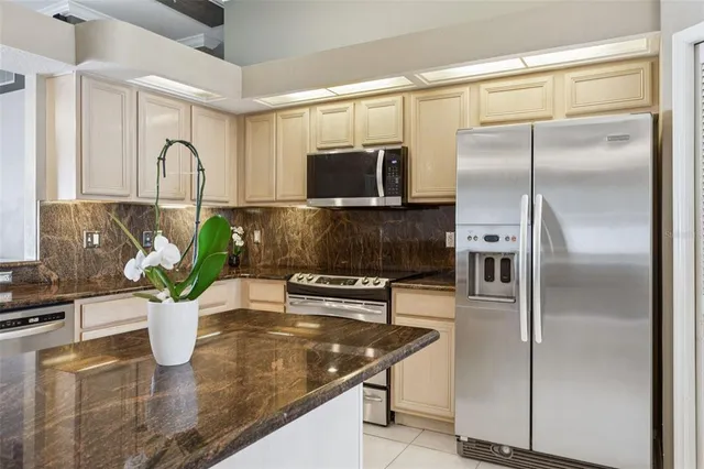 a kitchen with stainless steel appliances granite countertop a sink a stove and cabinets